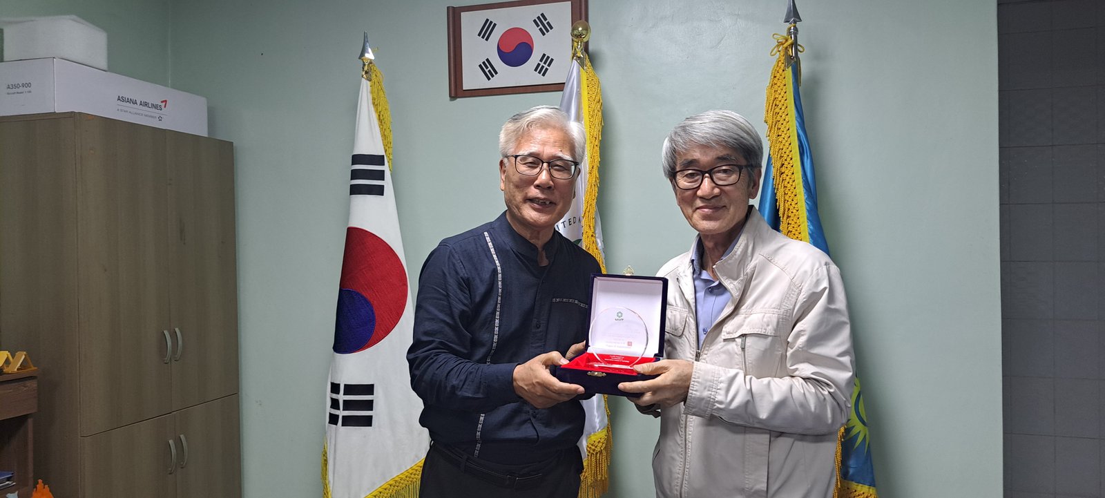 UAIT Director presenting commemorative plaque to faculty member