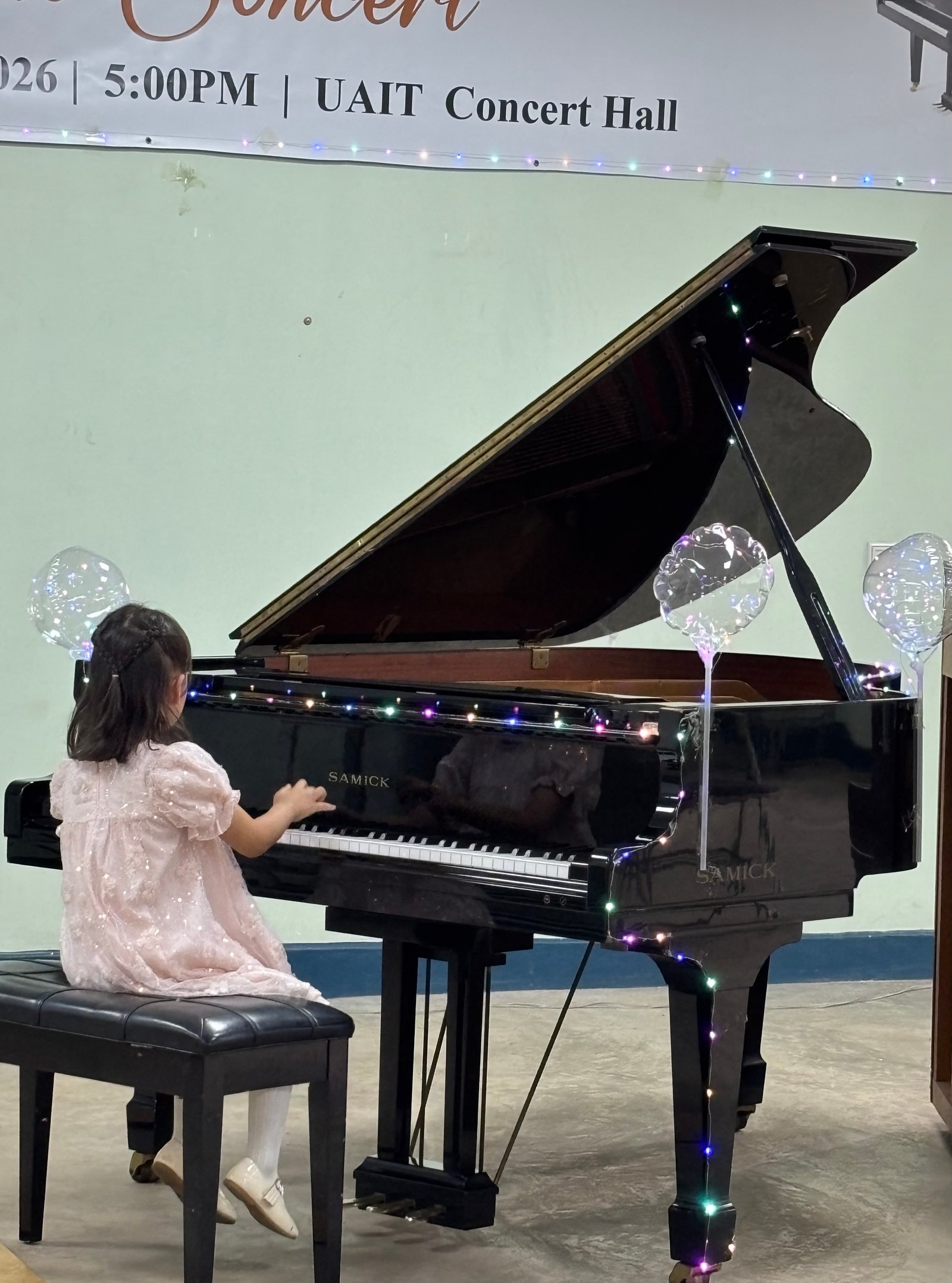 Young student performing a piece on the grand piano